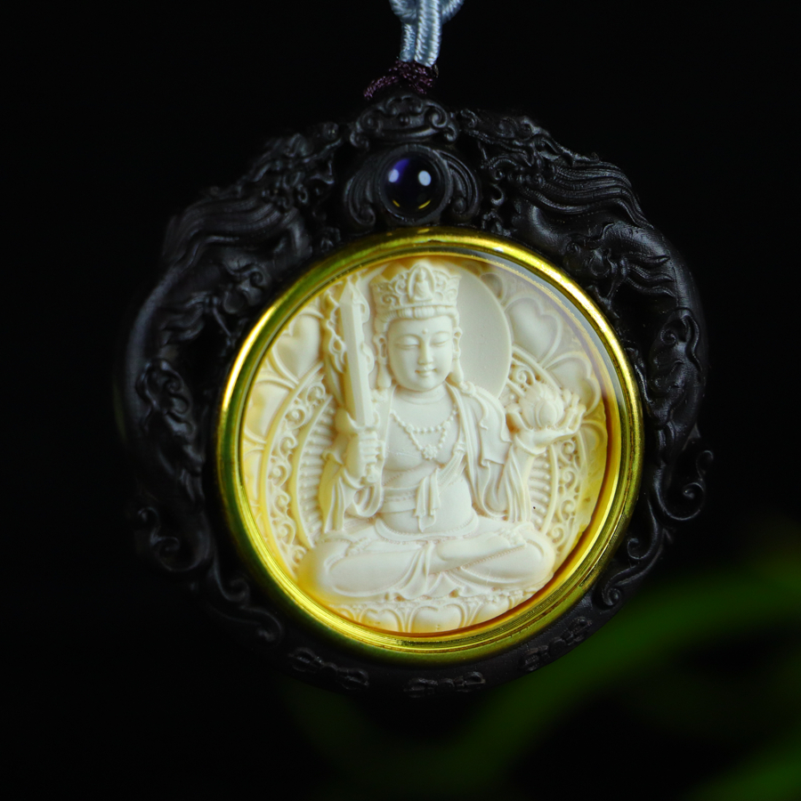A natural, top-quality mammoth ivory pendant inlaid with sandalwood and depicting the Bodhisattva Akasagarbha.