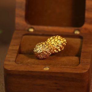 An old collection of a peanut-shaped object made of yellow metal.