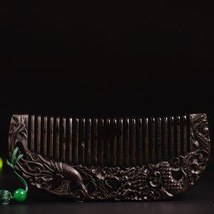 A natural old material black agarwood comb with carvings of dragons and phoenixes symbolizing good fortune. There is a certificate.